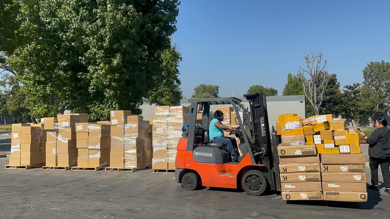 ShipHub (PAX Trading Inc) warehouse team member operating a forklift to move palletized, shrink-wrapped inventory at a fulfillment center